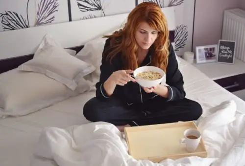 woman sick in bed eating food