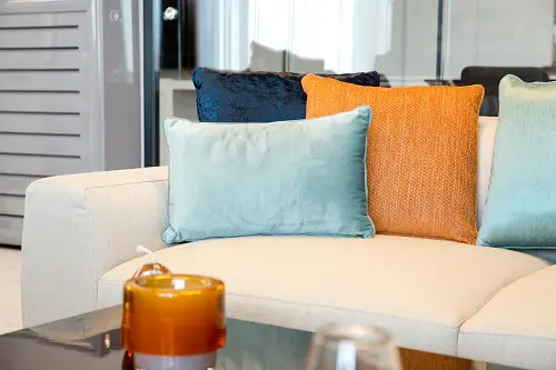 Blue & Orange Pillows On Beige Sofa