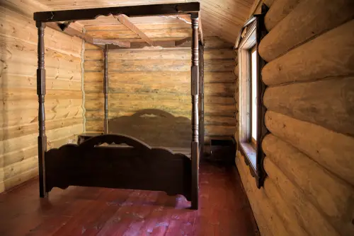 Wooden Rustic Canopy Bed in Log Cabin bedroom